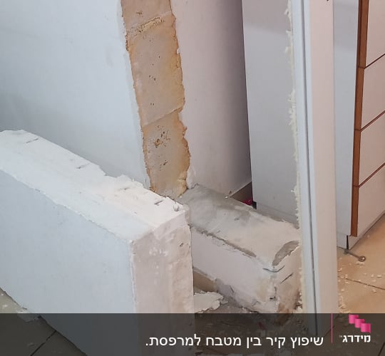קיר פתוח עם חלון, כלי עבודה וחומרי בנייה